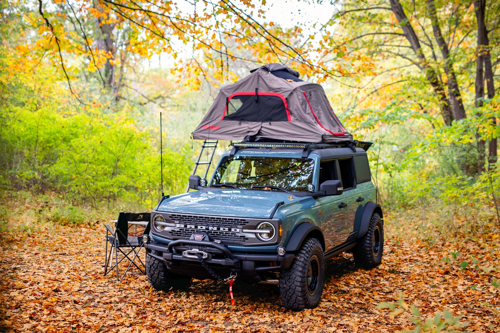 A close up of a vehicle with a tent on top of it (ford bronco, 2021, off roading, suv concept, 5k)