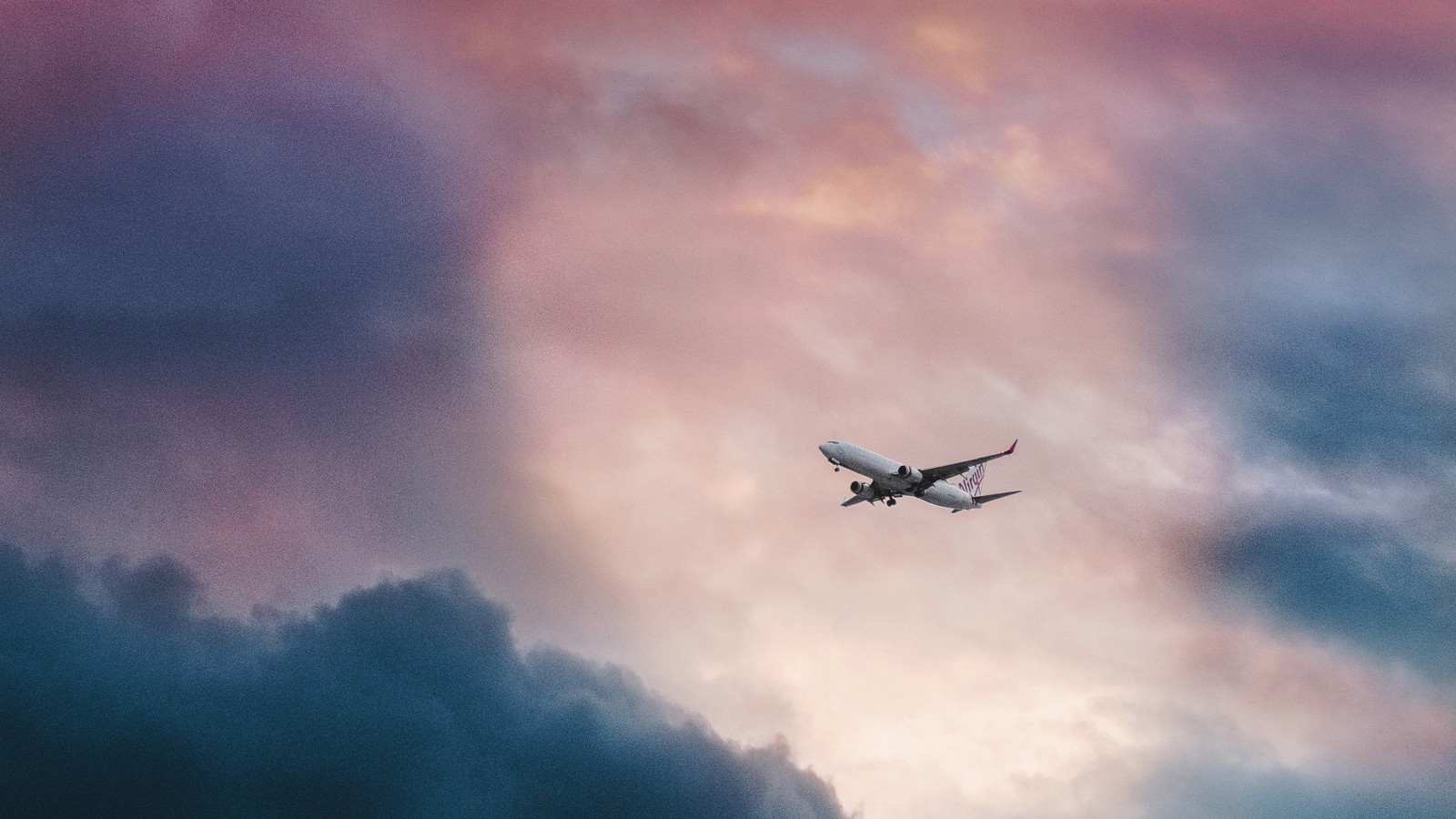 Un avion vole à travers les nuages au coucher du soleil (avion, vol, aéronef, voyage aérien, voyage)