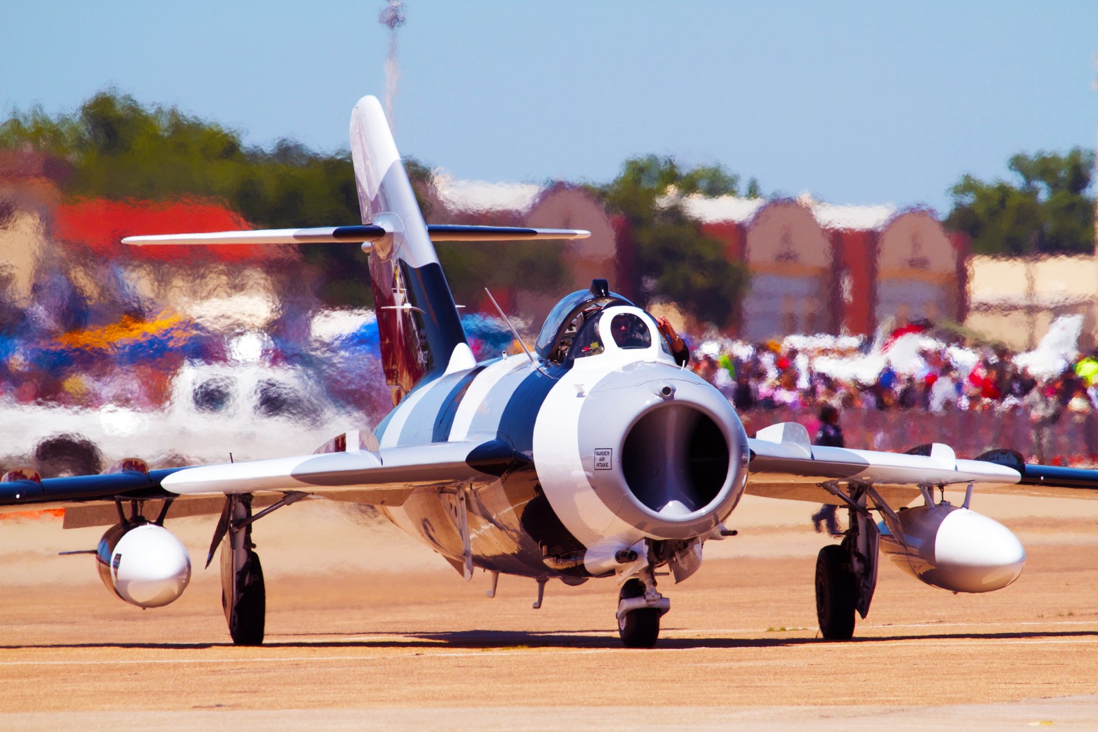 There is a small plane that is on the runway with people watching (airplane, aircraft, aviation, air force, jet aircraft)