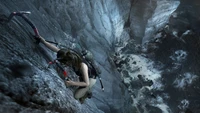 Lara Croft escalade une falaise rocheuse, équipée pour l'aventure dans "L'Ombre du Tombeau.