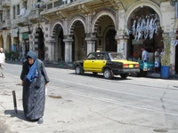 Escena de calle de la ciudad con peatón y coches compactos