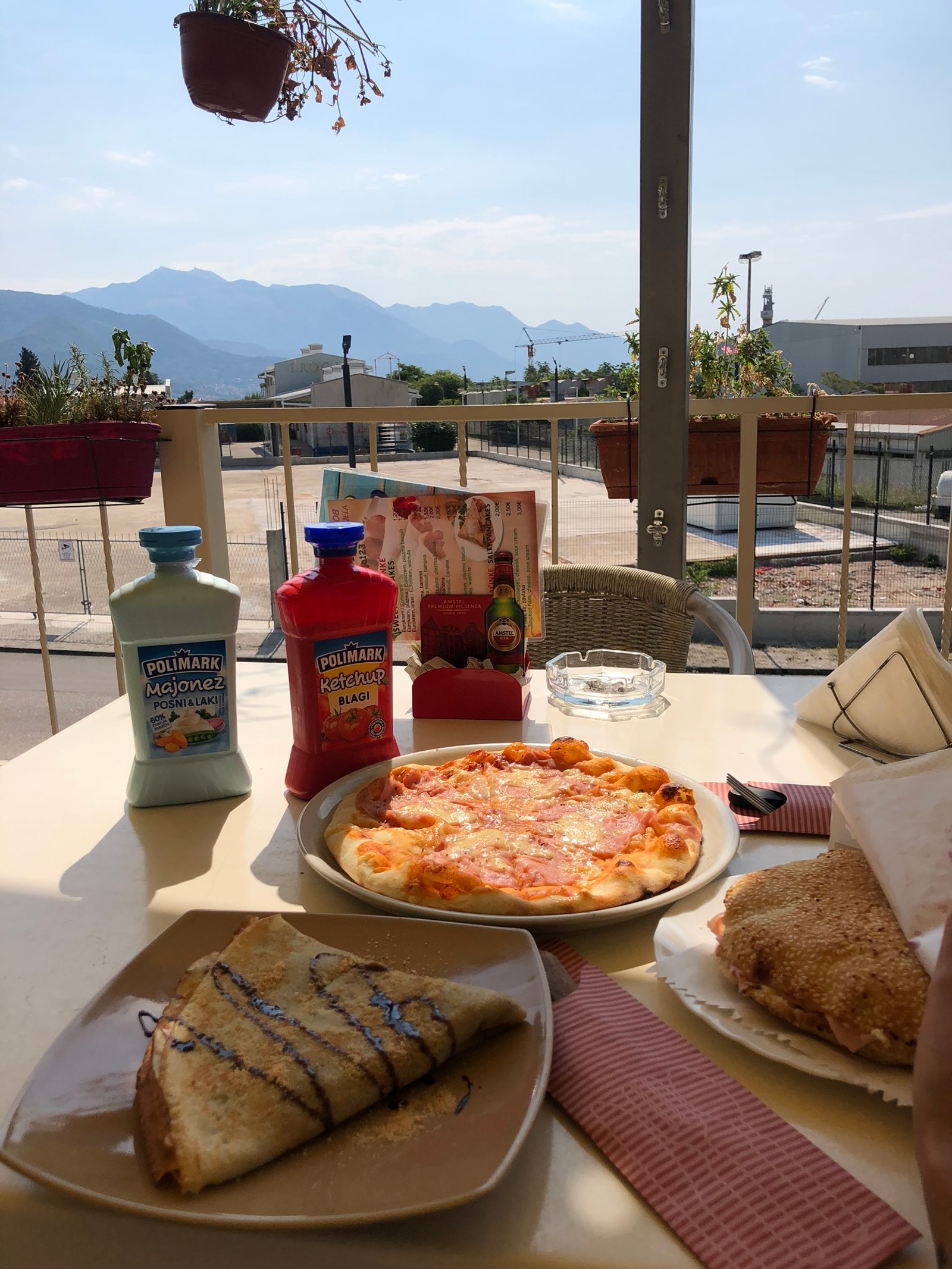 Auf einem tisch mit blick liegen pizza und ein sandwich (mahlzeit, frühstück, brunch, gewässer, brot)