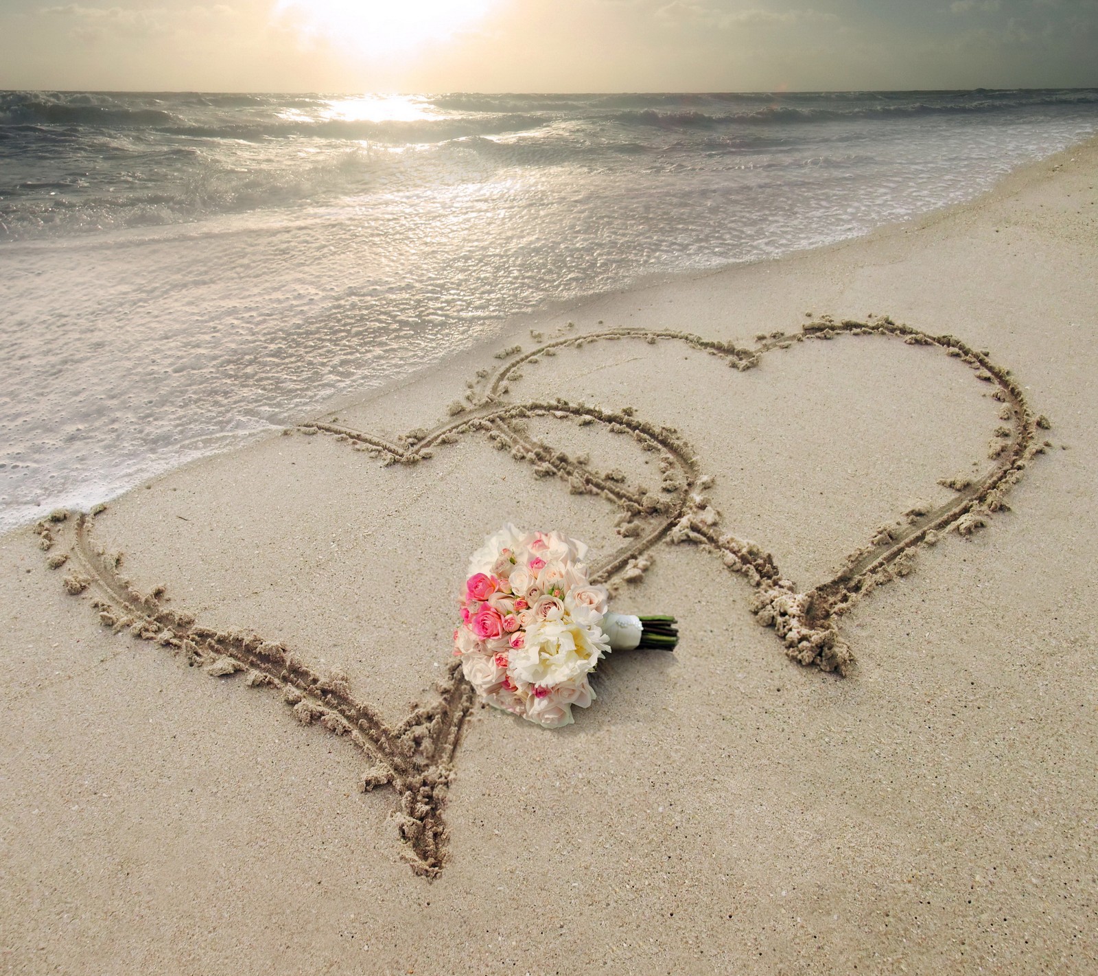 Deux cœurs dessinés dans le sable avec des fleurs sur la plage (plage, fleurs, cœurs, amour, romance)