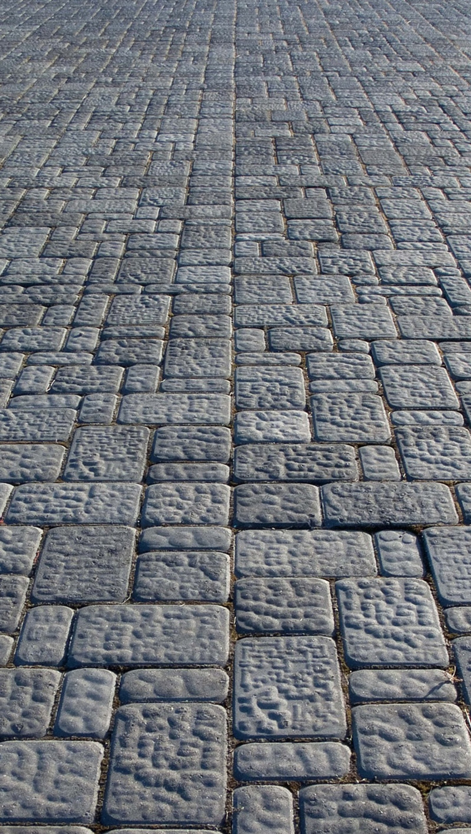 Arafed view of a cobblestone street with a red fire hydrant (paving, stone)