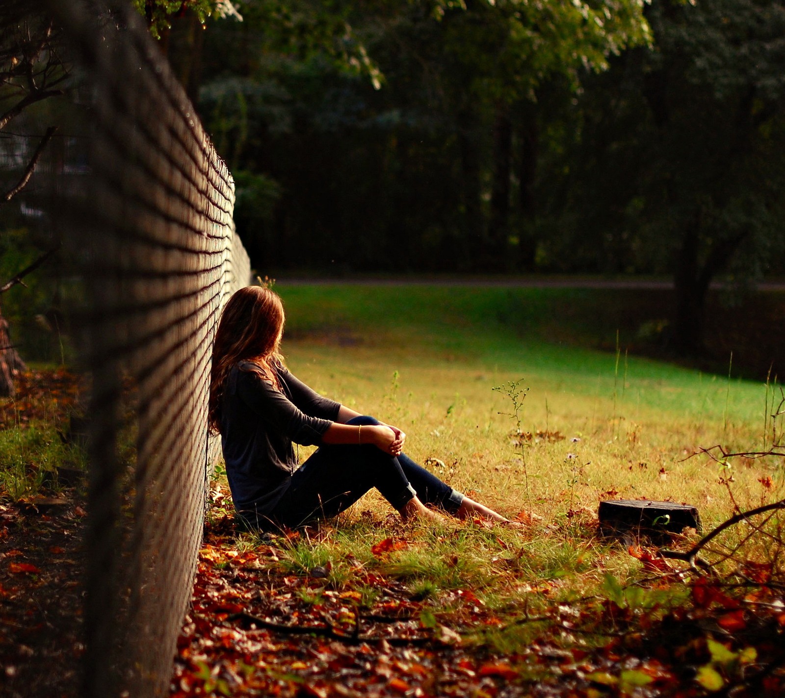 Há uma mulher sentada no chão na grama (autumn beauty, menina, natureza)