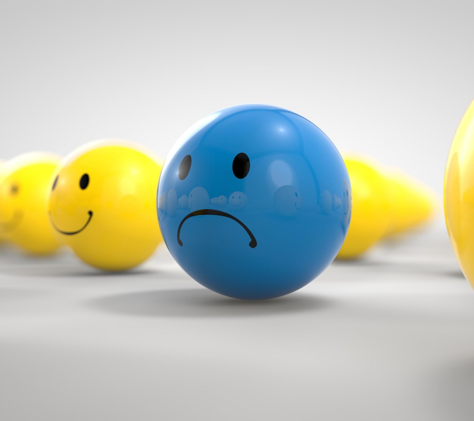 Yellow and blue balls with sad faces in a row (ball, between, blue, sad, smile)