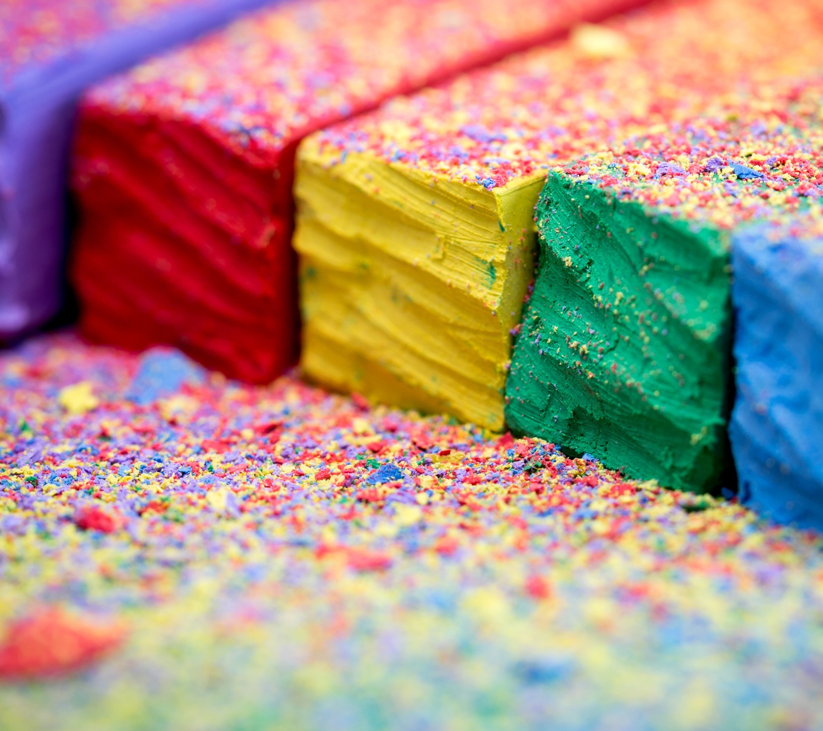 Un gâteau coloré avec des vermicelles et un couteau sur le dessus (bleu, craie, coloré, couleurs, focus)