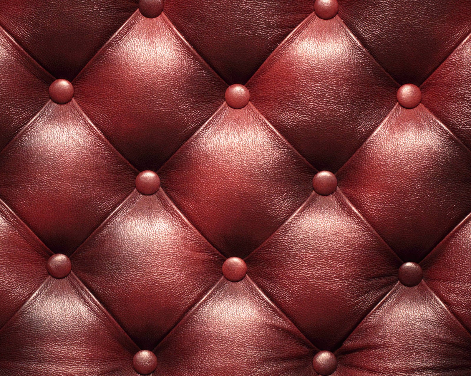 A close up of a red leather upholstered with buttons (leather, obbivka)