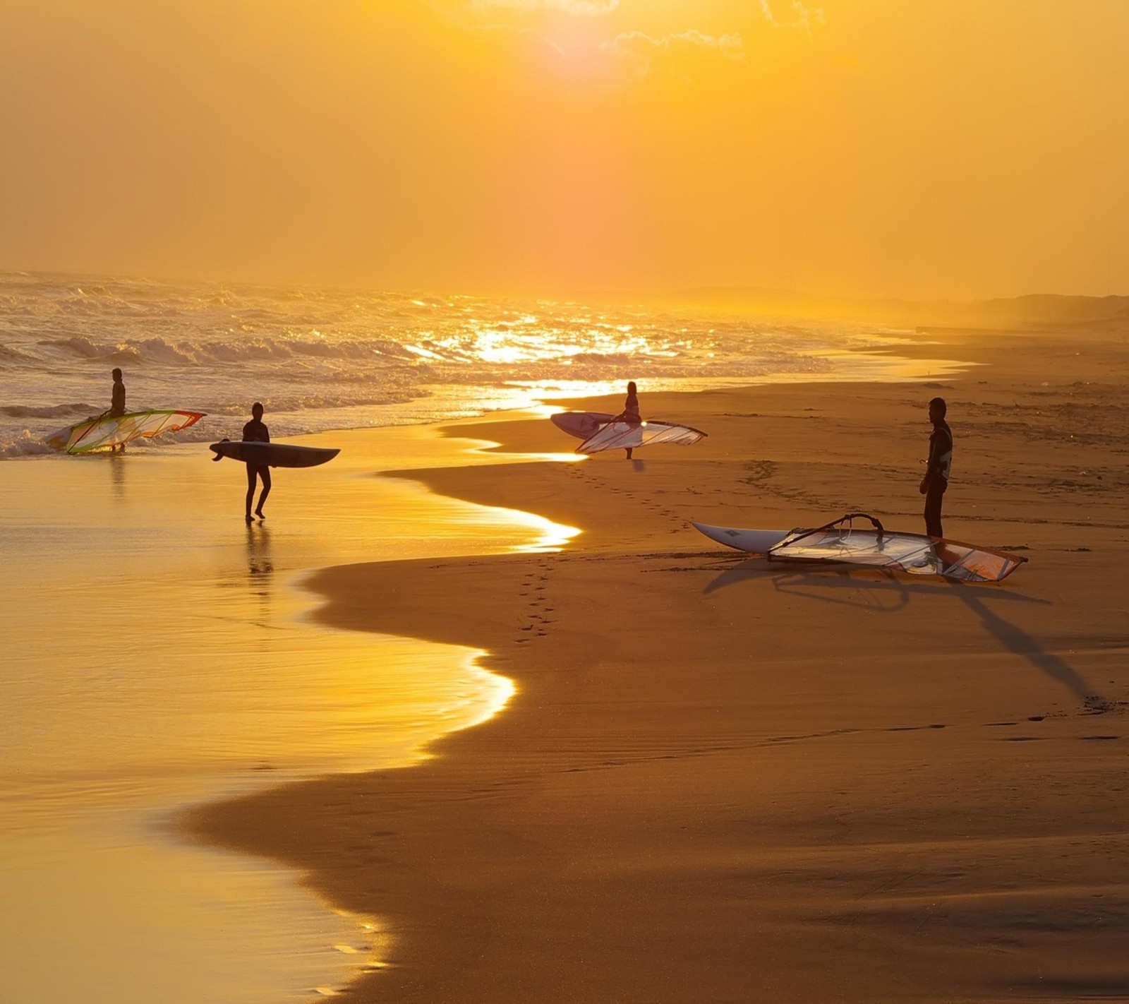 Surfers are walking along the beach at sunset with their surfboards (beach, cool, nice, sunset)