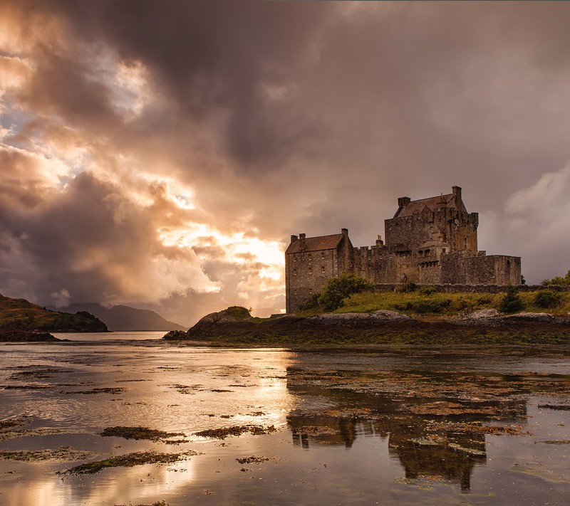 Вид на замок на холме с облачным небом (eilean donan castle, шотландия)