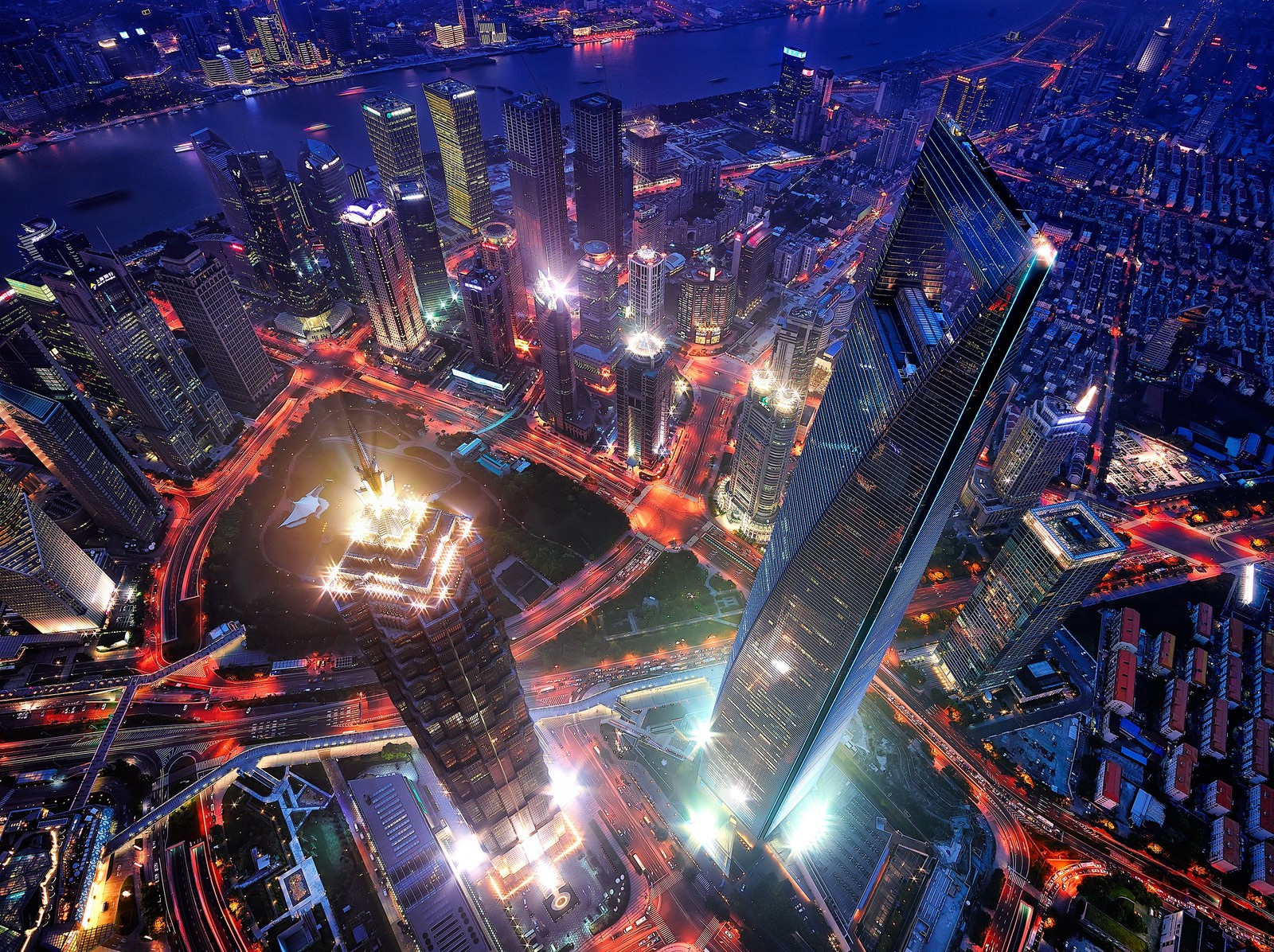 Una vista de una ciudad de noche con mucho tráfico (centro financiero mundial de shanghái, torre jin mao, jin mao tower, torre de shanghái, ciudad)