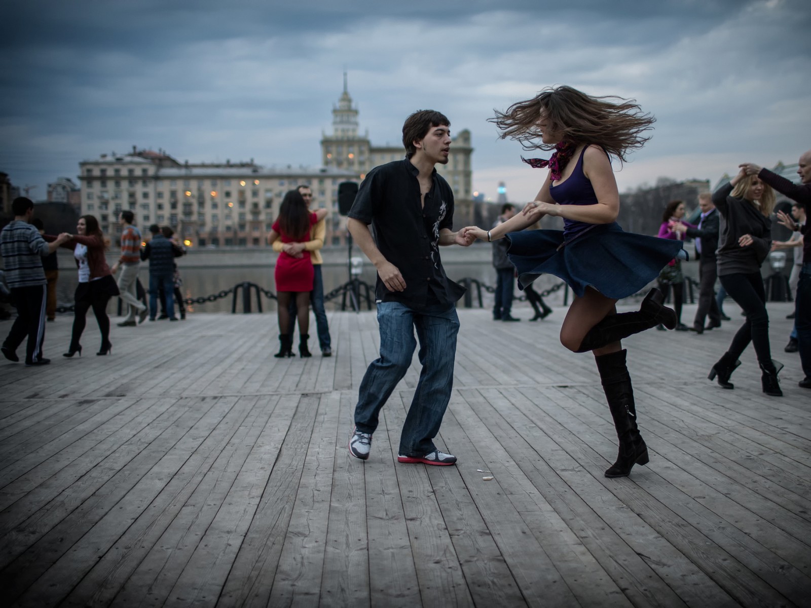 Hay muchas personas de pie en un suelo de madera en una ciudad (moscú, danza, artes escénicas, evento, diversión)