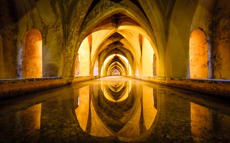 Длинный туннель с отражением света в нем (древняя архитектура, real alcazar of seville, королевский дворец, испания, 5k)