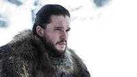 Jon Snow in a snowy landscape, wearing a fur cloak, reflecting a somber determination.