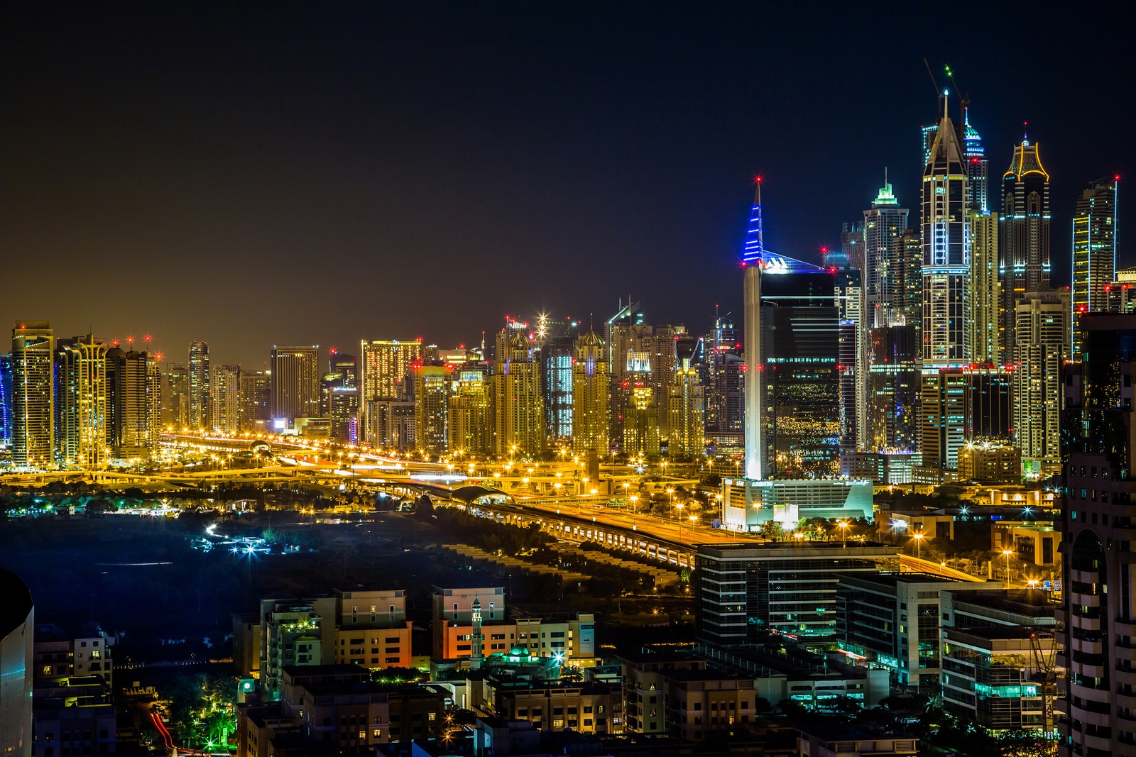 Vista de uma cidade à noite com muitas luzes (cidade, paisagem urbana, metrópole, área urbana, noite)