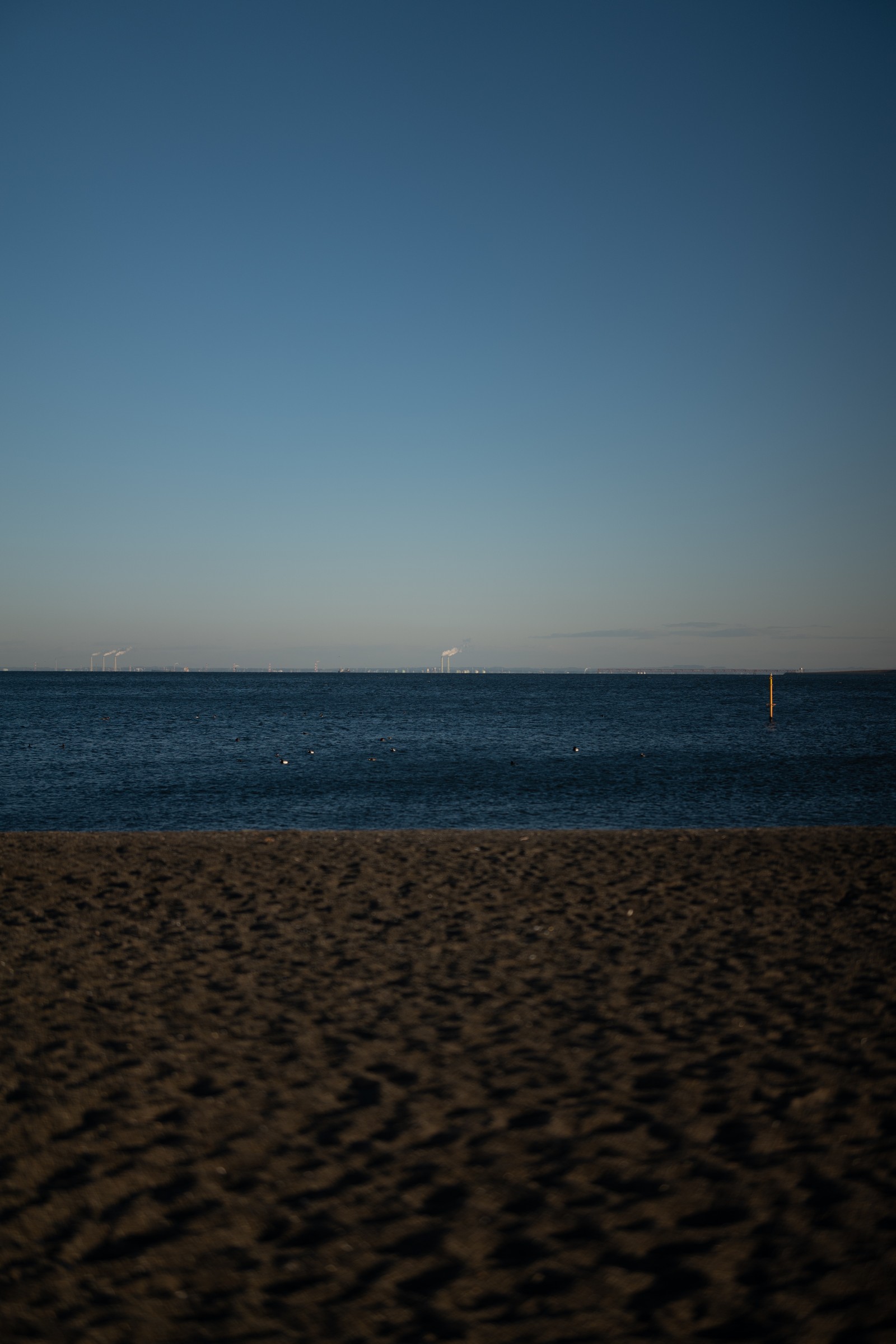 Il y a un voilier solitaire sur l'eau au loin (horizon, vague, eau, ciel, plage)