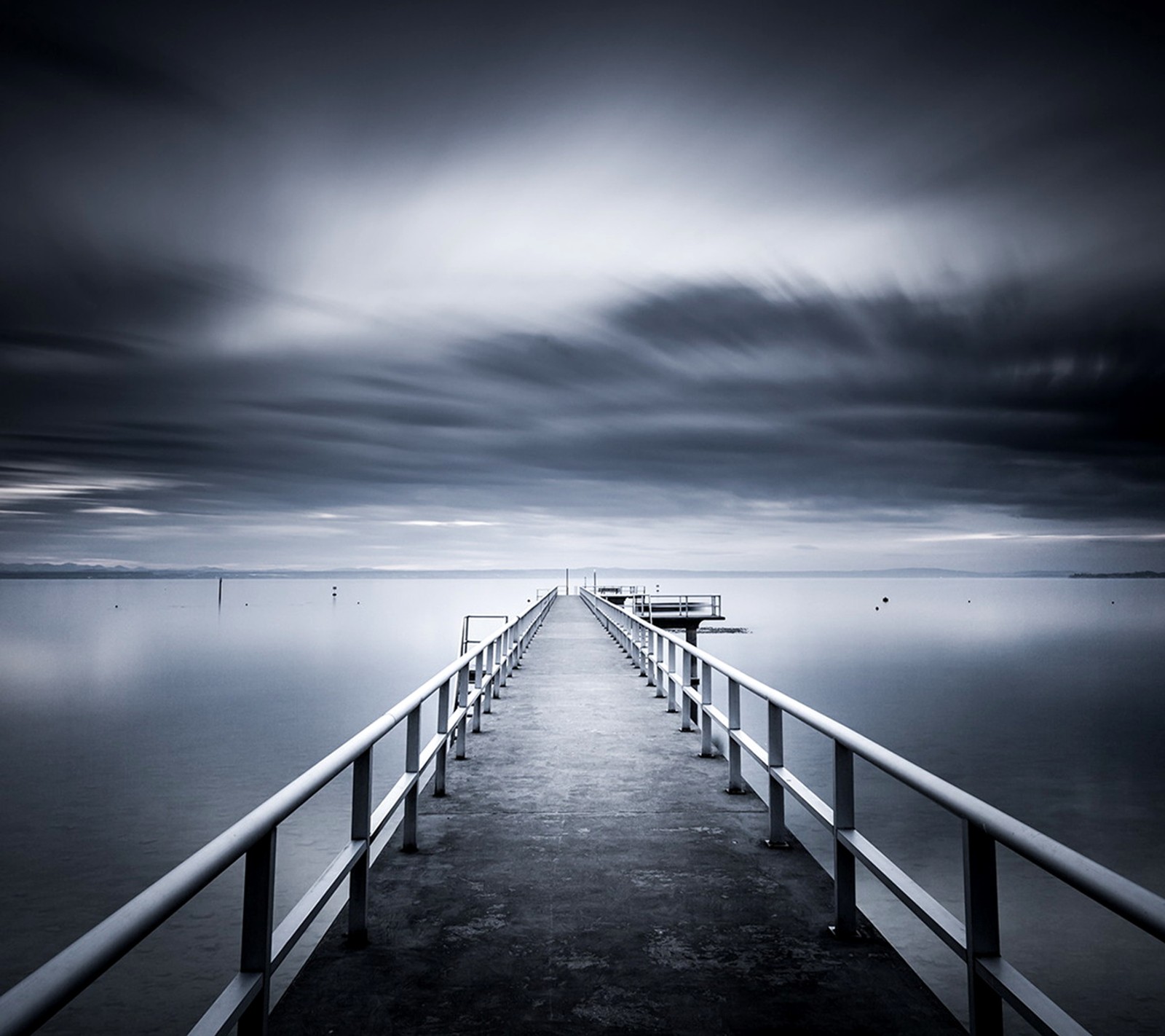 Un quai avec un bateau sur l'eau sous un ciel nuageux (argent, ciel)