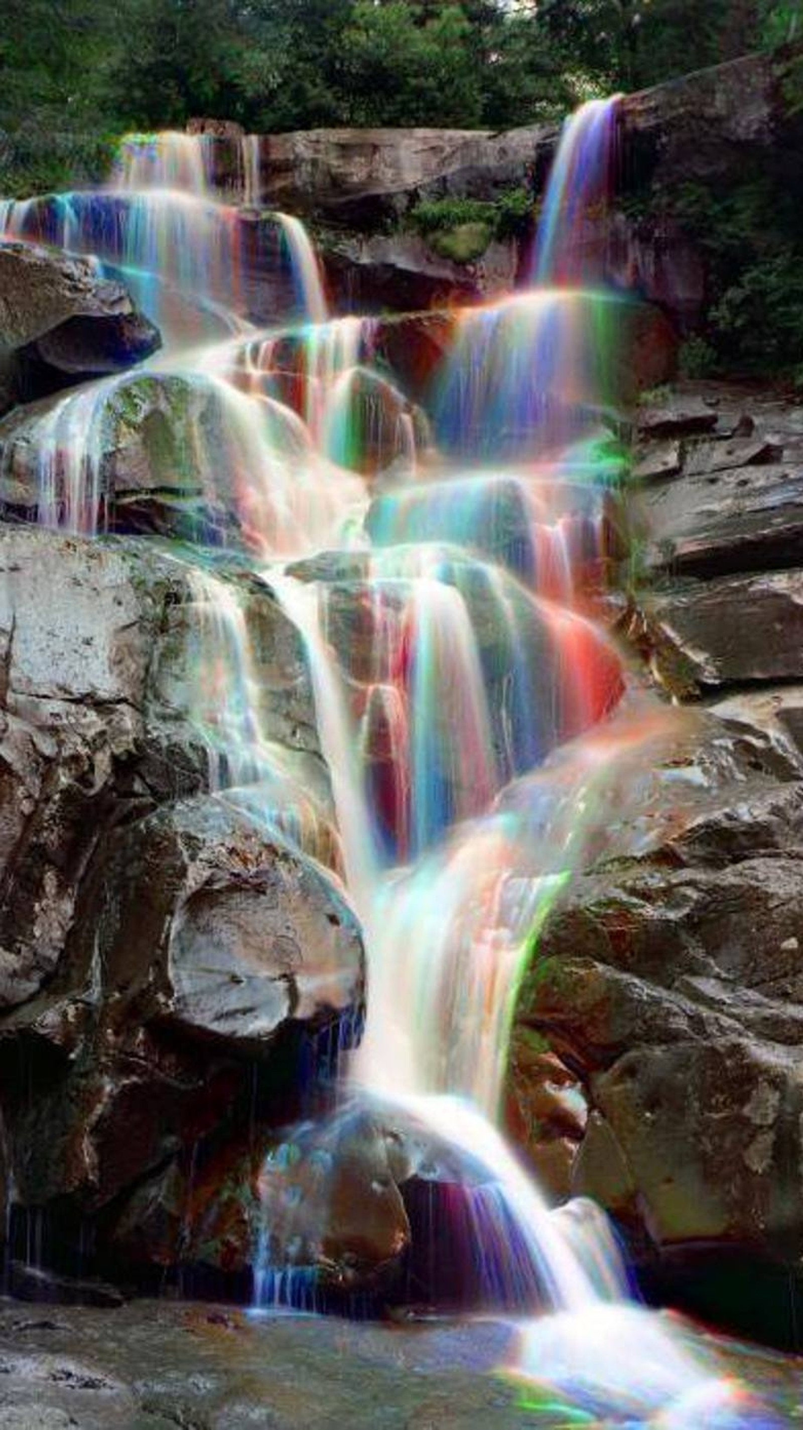 A close up of a waterfall with a rainbow effect on it (nature, rainbow, waterfalls)