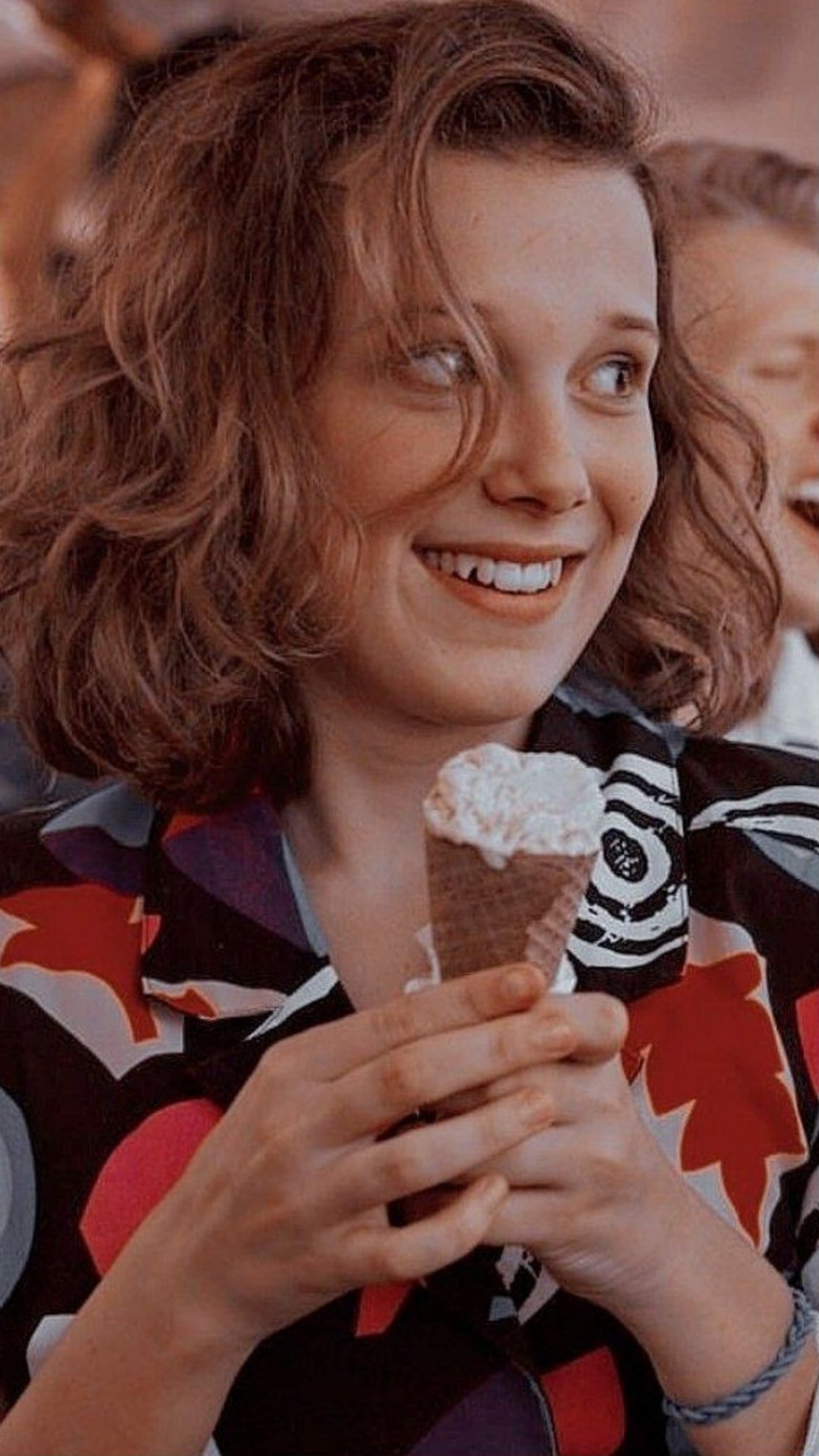 Une femme tient un cornet de glace dans sa main. (onze, stranger things)