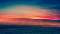 Paisaje matutino vibrante con colinas onduladas bajo un cielo colorido