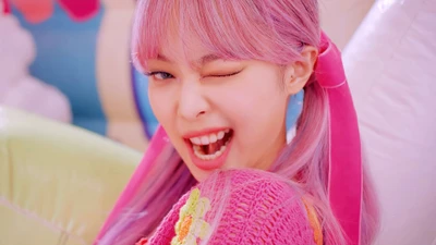 Jennie from BLACKPINK winking playfully with pink hair, surrounded by vibrant colors and playful decor.