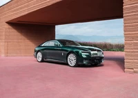 Smaragdgrüner Rolls Royce Spectre vor modernem architektonischen Hintergrund