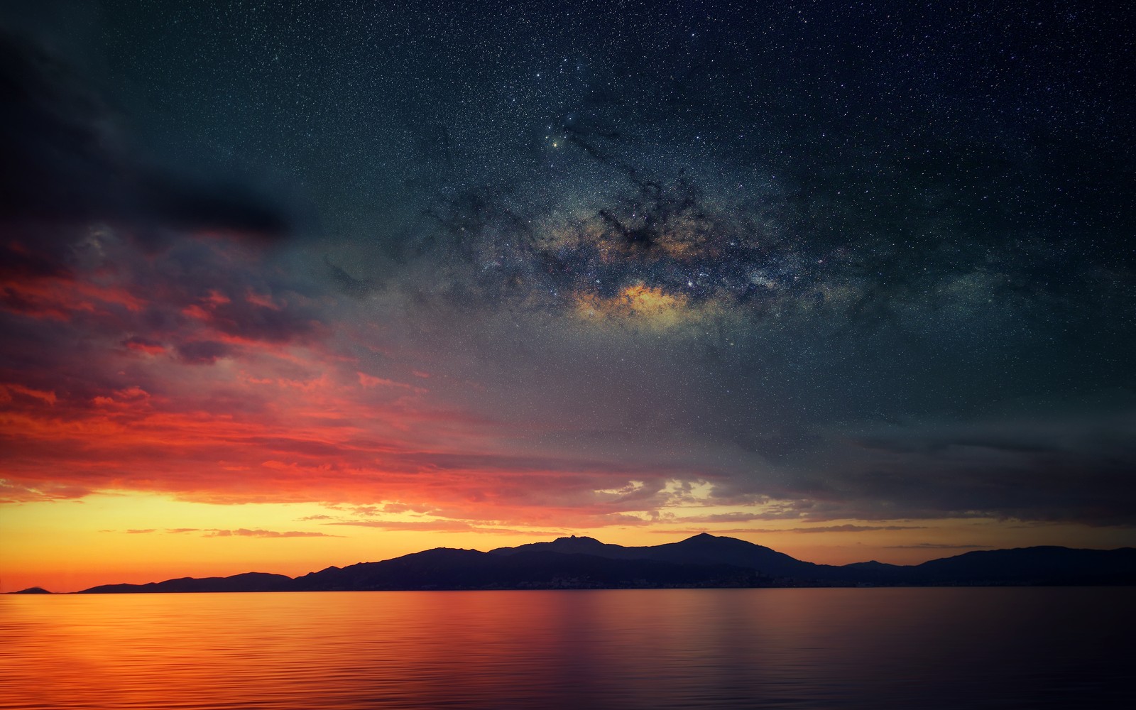 A view of the milky and the stars above the ocean (corsica island, sunset orange, silhouette, landscape, astronomy)