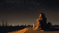 Chica solitaria mirando las estrellas con su gato bajo un cielo nocturno