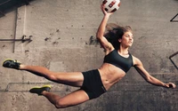 Goleiro dinâmico no ar, mostrando atletismo enquanto se prepara para pegar uma bola de futebol.