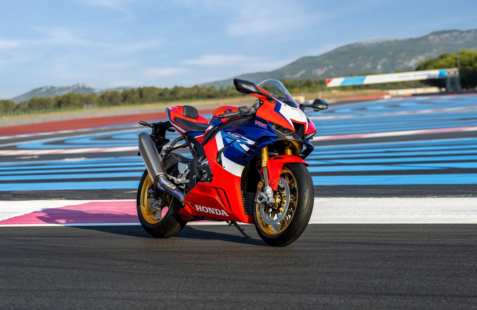 Arafed motorcycle on a race track with mountains in the background (honda cbr1000rr r fireblade sp, race track, sports bikes, 2022, bikes)