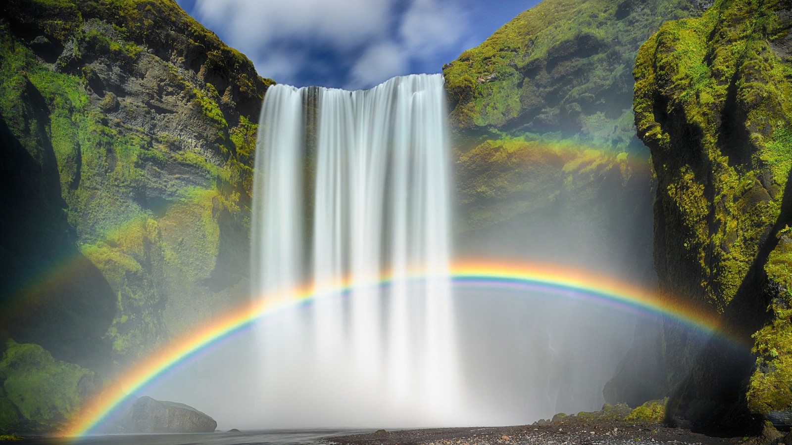 A close up of a rainbow in front of a waterfall (waterfall, rainbow, body of water, nature, water)