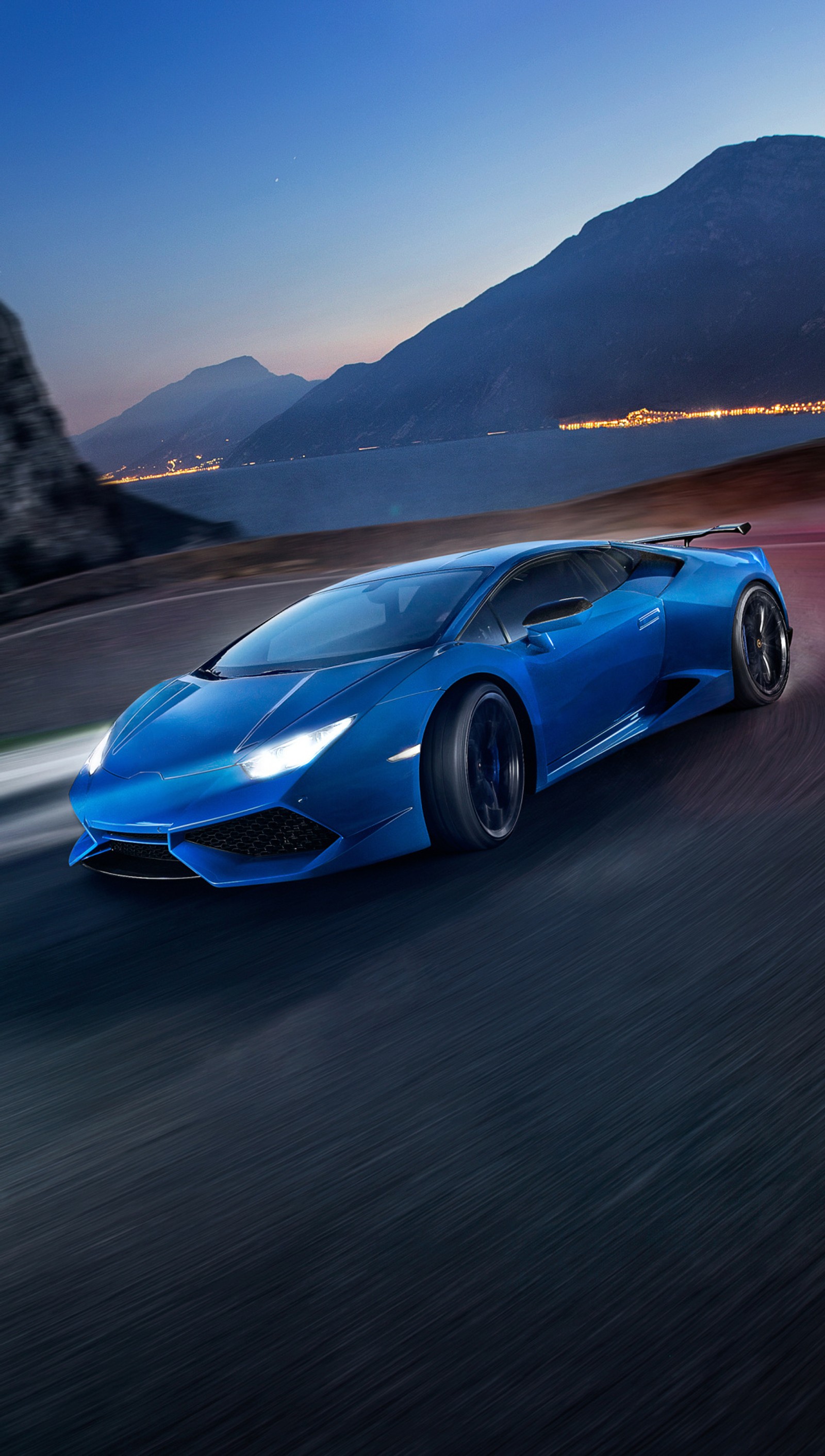 Un primer plano de un coche deportivo azul conduciendo por la carretera (huracan, lamborghini, supercoche)