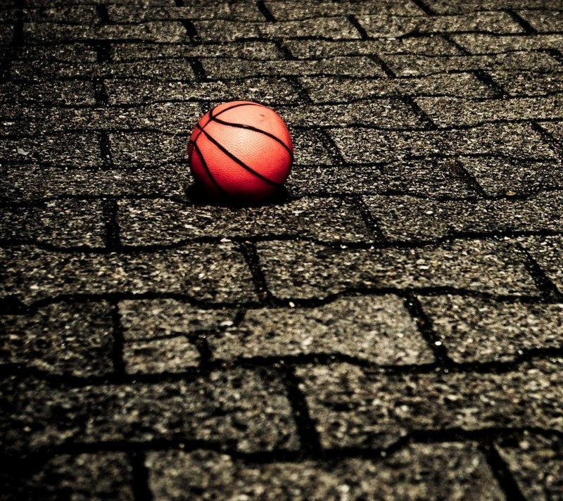 Primer plano de un balón de baloncesto en un camino de ladrillos (pelota, calle, vintage)