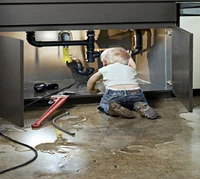 Child Engaged in Plumbing Work Underneath a Sink