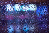 Gotas de lluvia vibrantes sobre una superficie con bokeh azul eléctrico y violeta