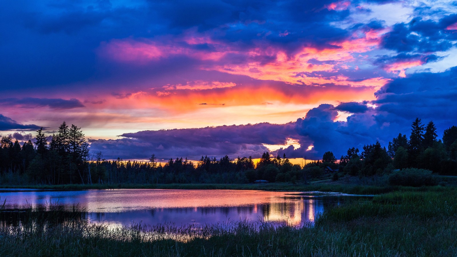 Una vista de un lago con un atardecer de fondo (amanecer, cielo, nubes, naturaleza, paisaje)