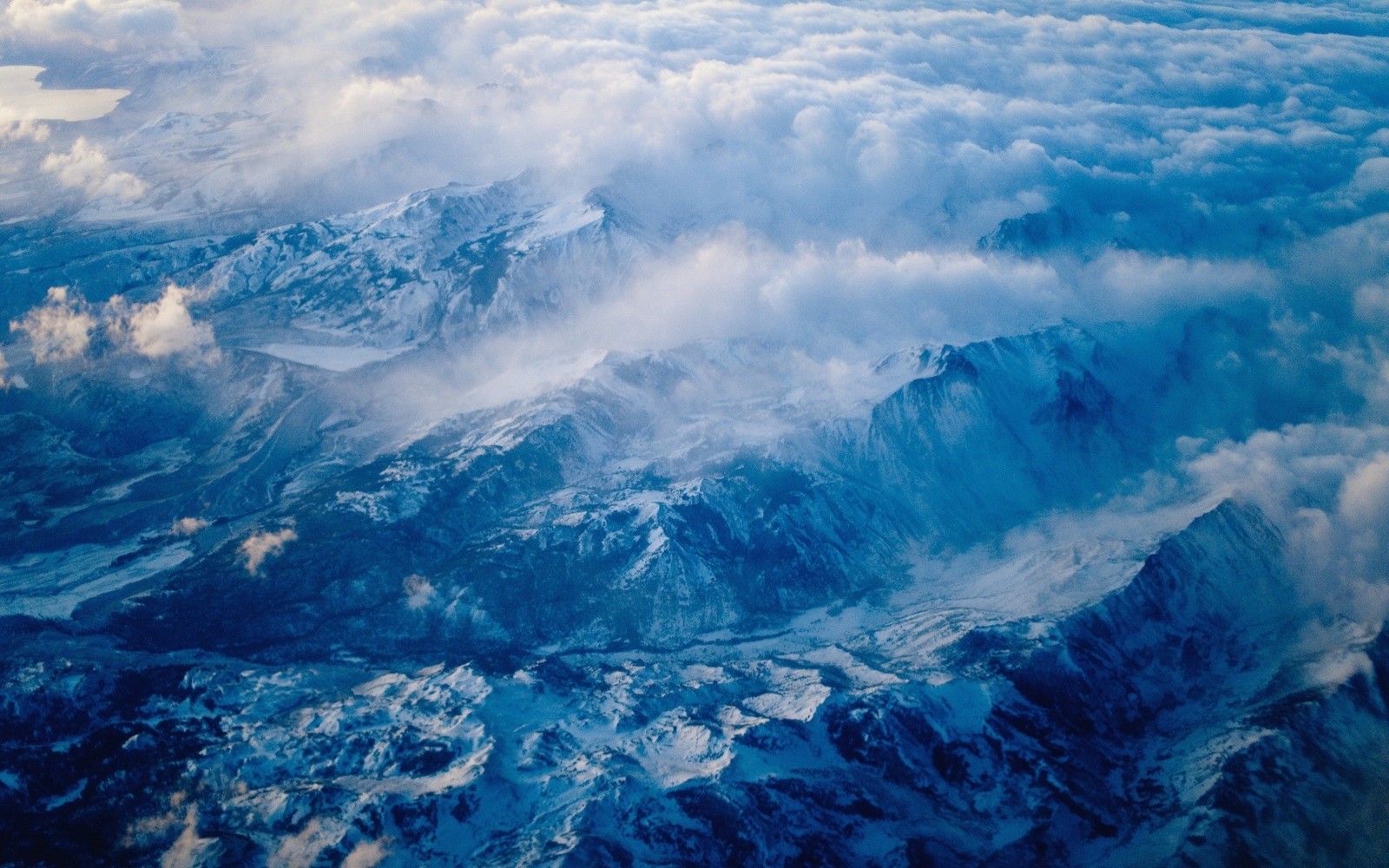 Vue d'une chaîne de montagnes avec des nuages et de la neige dans le ciel (chaîne de montagnes, nuage, montagnes, photographie aérienne, nuages)