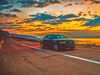 Audi A4 élégant sur une route côtière pittoresque au coucher du soleil