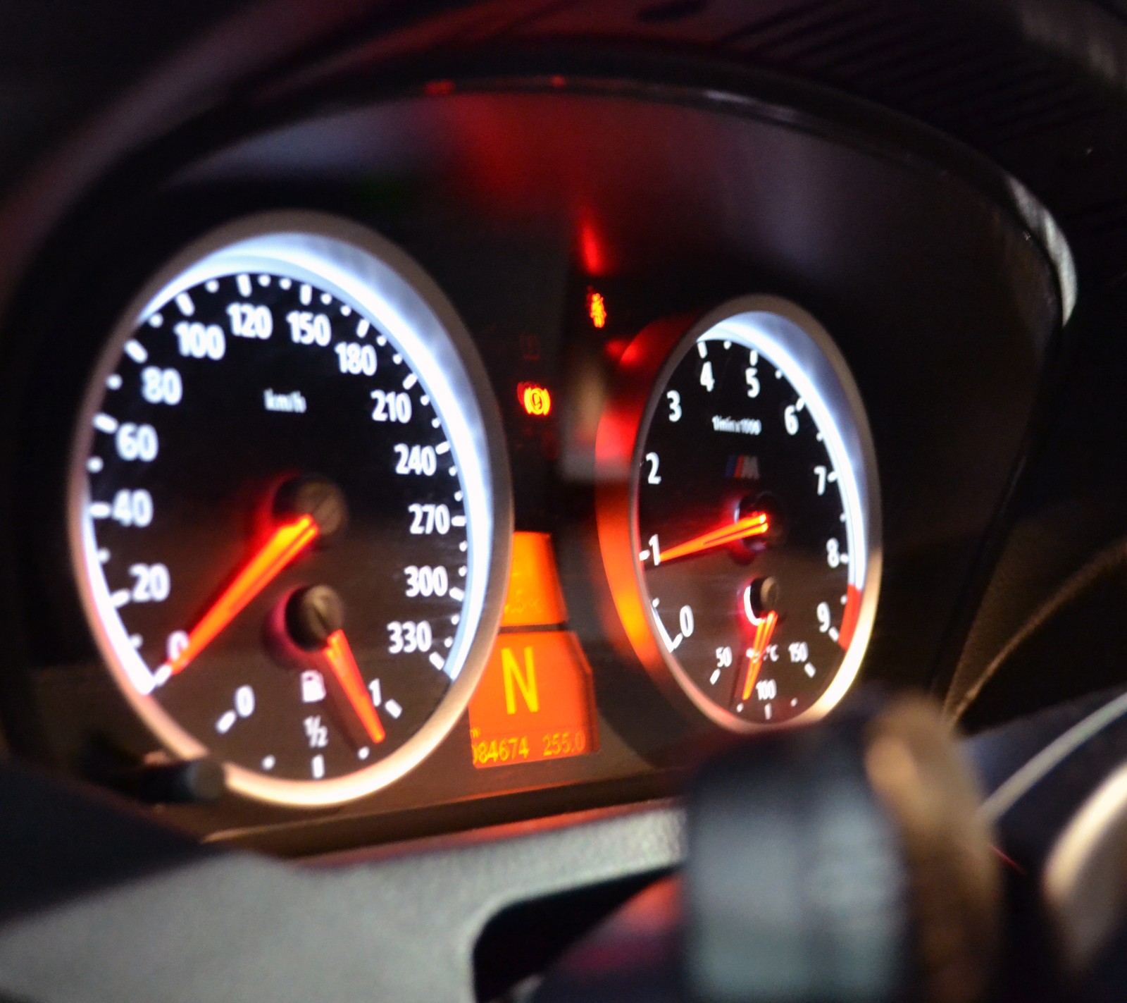 A close up of a dashboard with a speedometer and a clock (bmw, m6)