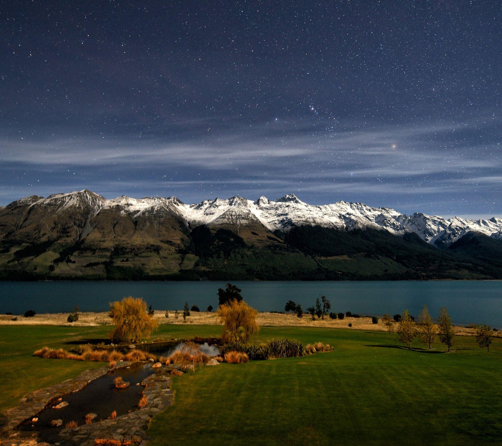 Mountains and a lake in the distance with a sky full of stars (nature, stars in sky, wonderful nature, wonderful sky)