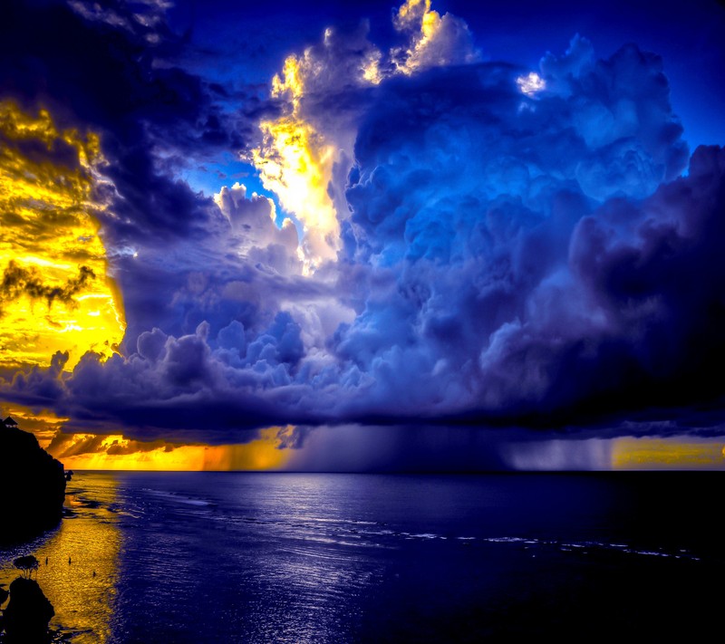 A close up of a person sitting on a beach under a cloudy sky (landscape, wallpaper)