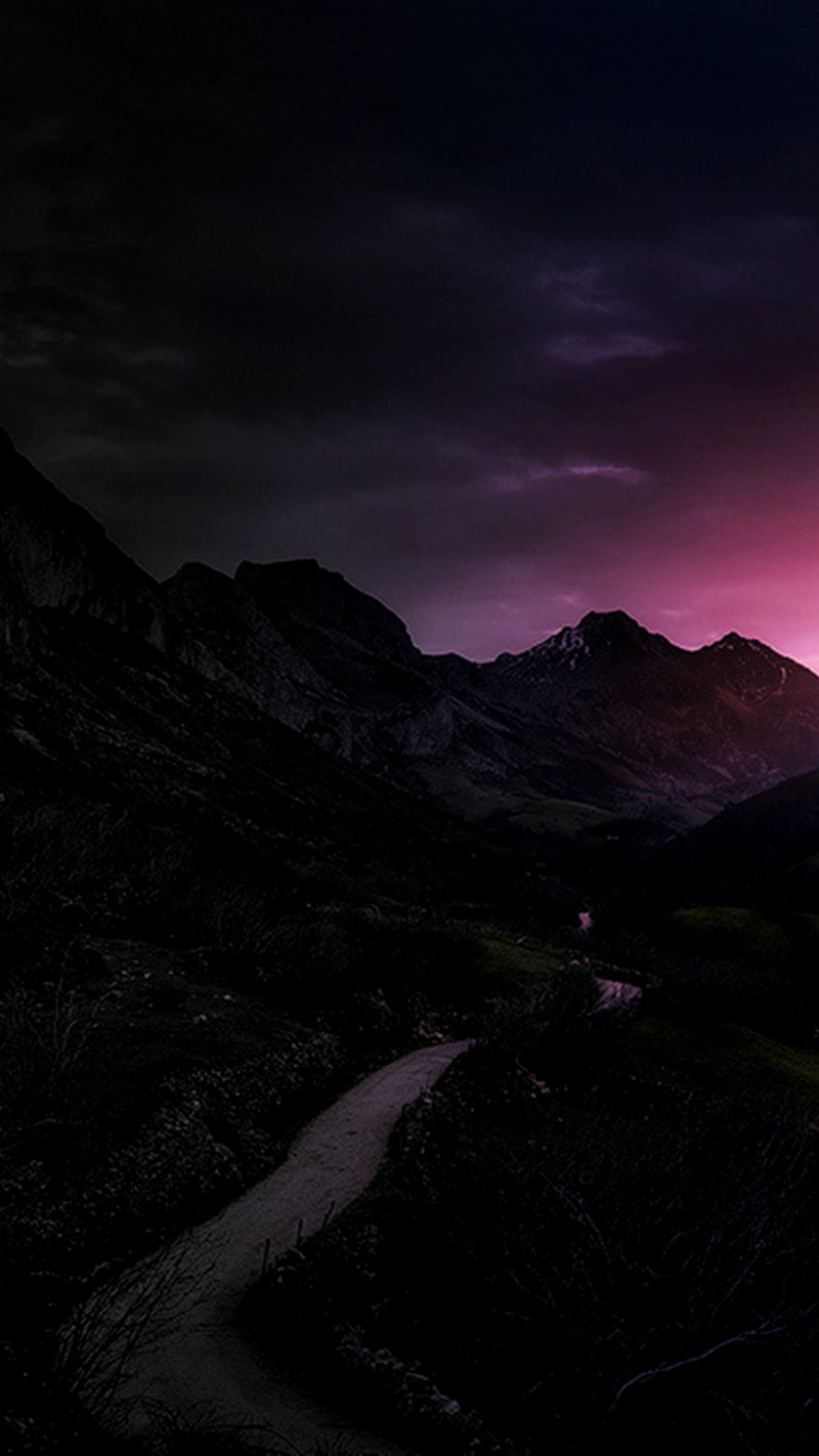 Coucher de soleil violet et noir sur une chaîne de montagnes avec une route sinueuse (ciel, paysage)