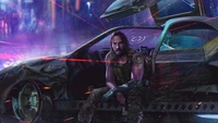 Johnny Silverhand in einer futuristischen, dystopischen Umgebung, neben einem beschädigten Fahrzeug sitzend, verkörpert das Wesen von Cyberpunk 2077.