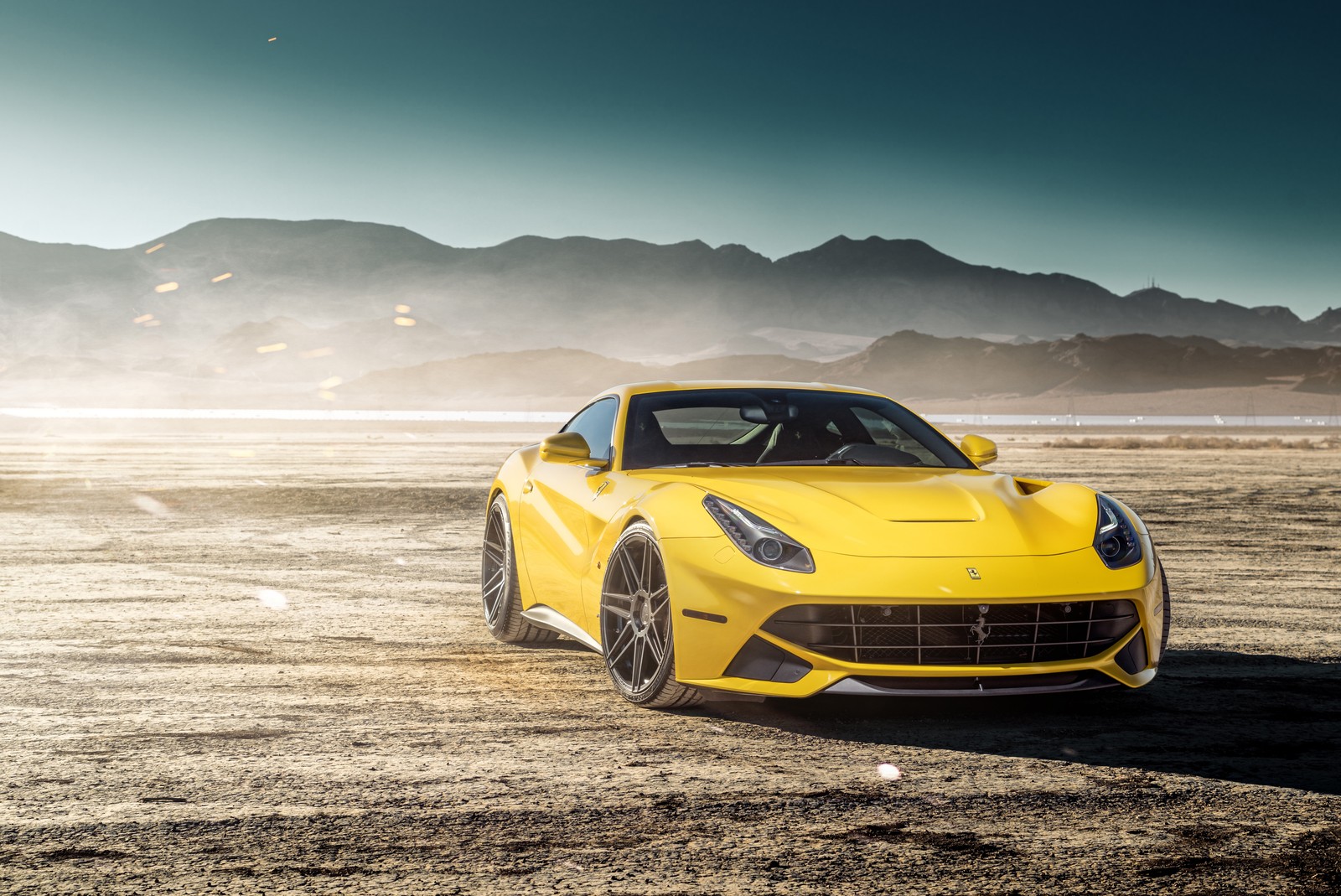 Ein gelbes ferrari-sportauto, das in der wüste geparkt ist (ferrari f12, sportwagen, auto, superauto, gelb)