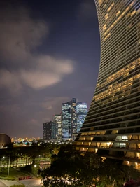 Nighttime Cityscape of Singapore with Modern Skyscrapers and Curved Architecture