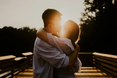 Abrazando el amor: Un beso de pareja en la luz dorada del sol