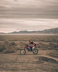 Rider in Action on a Desert Trail with Mountains in the Background