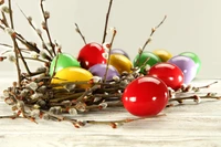 Colorful Easter eggs nestled among catkins and branches.