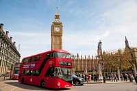 Roter Doppeldeckerbus fährt an Big Ben in einer geschäftigen Londoner Stadtlandschaft vorbei