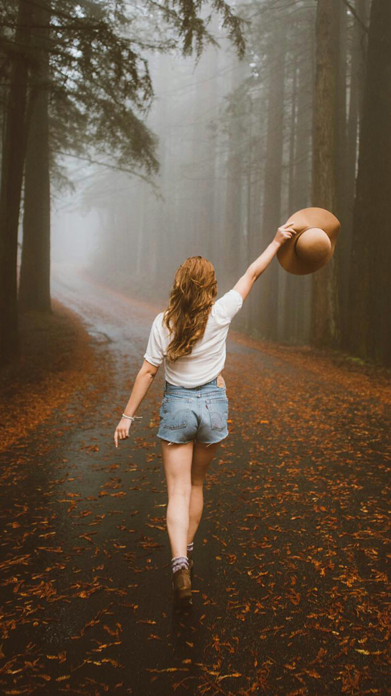 Eine frau läuft im wald mit einem basketball in der hand (herbst, nebel, mädchen, stimmung, natur)